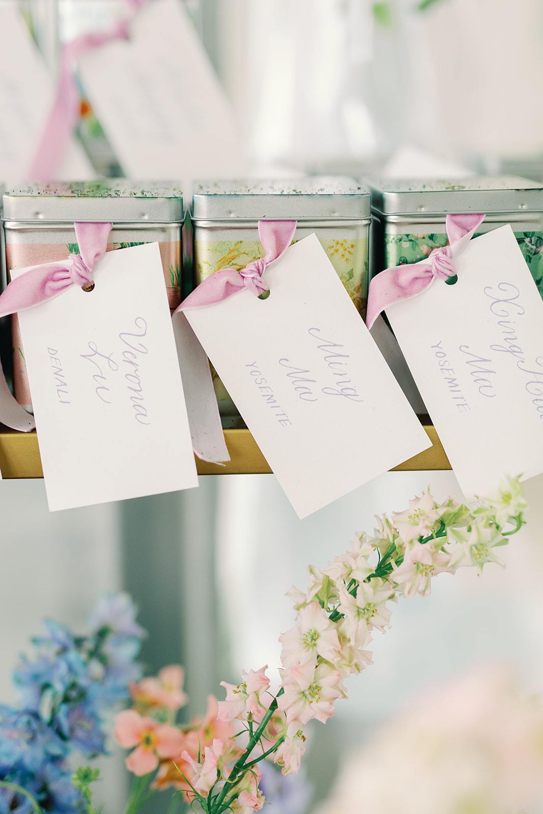 Wedding escort cards with hand calligraphy guest names and table names tied with purple ribbon at Hershey Gardens wedding venue in Hershey, Pennsylvania.