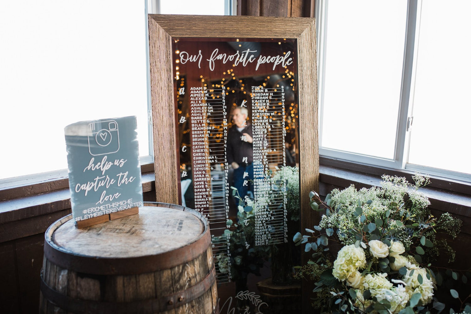 Hand calligraphy wedding mirror seating chart with florals and Instagram sign at Wind in the Willows wedding venue in Hershey, Pennsylvania.