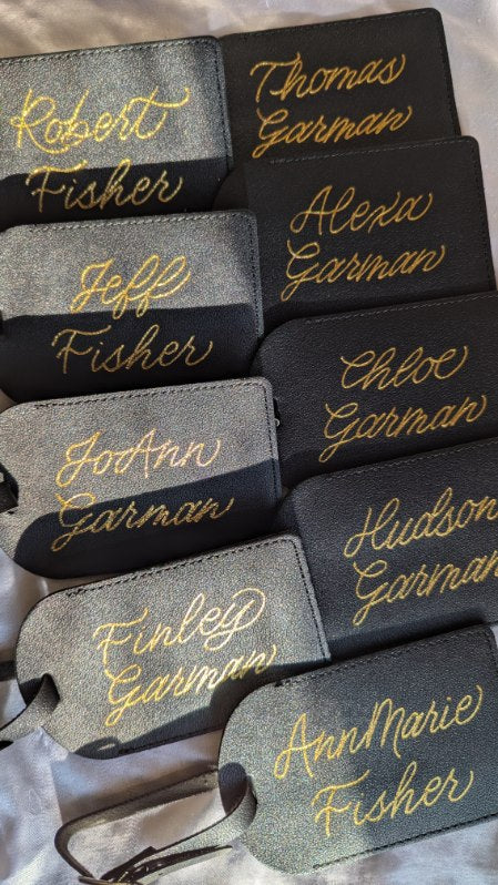Hand heat foiled black leather luggage tags with gold foil, personalized with family names as travel gifts from a daughter to her extended family for their trip to Germany. Elegant and meaningful keepsakes for travel and gifting.