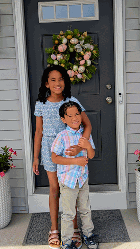Calligrapher Tiffany’s children smiling on Easter weekend, standing in front of a festive front door with a spring wreath — a glimpse into the family behind SLM & Design Co., a Southcentral Pennsylvania-based wedding calligraphy and engraving business.