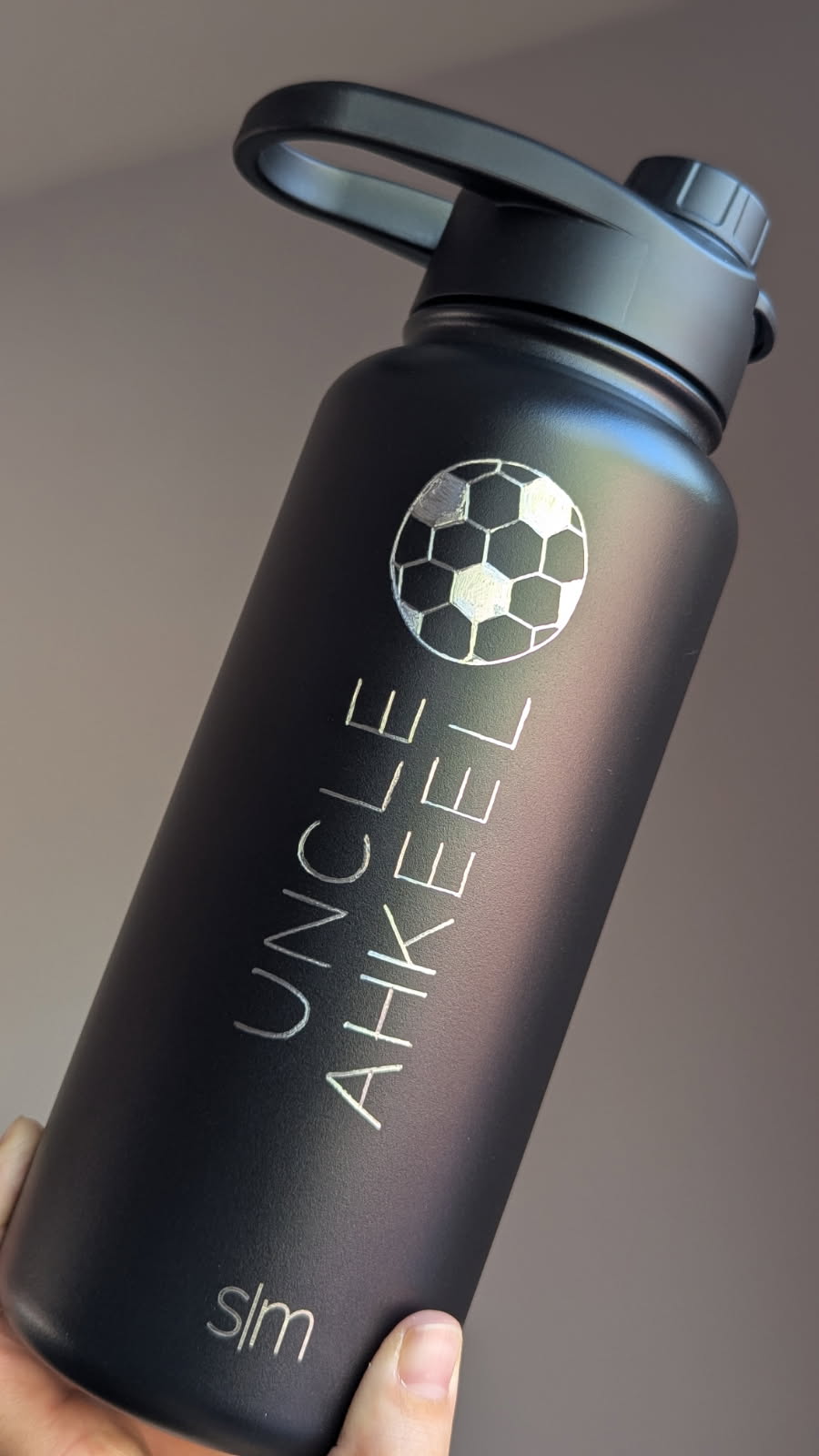 Custom engraved black water bottle with soccer design and name