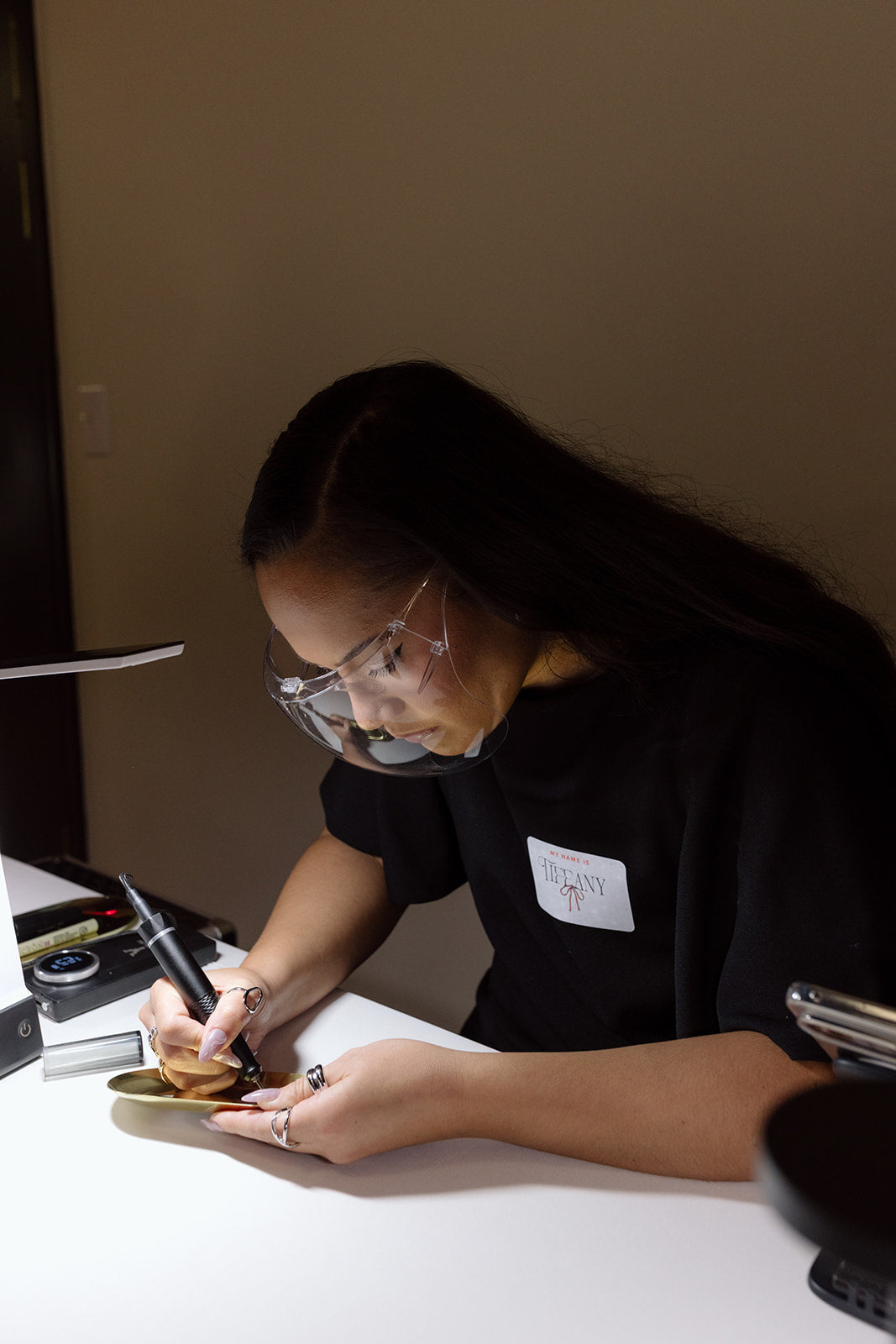 Live event artist Tiffany hand engraving gold jewelry trays during the Faire Sol women empowered event in Lancaster, Pennsylvania.